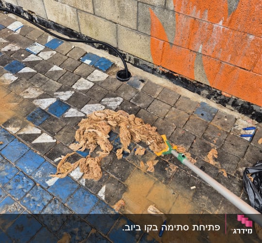 צינור שחור מחובר לקיר, נוזלים על הרצפה